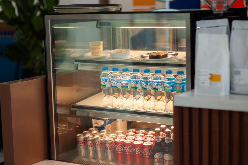 Café refrigerator displaying chilled drinks and desserts