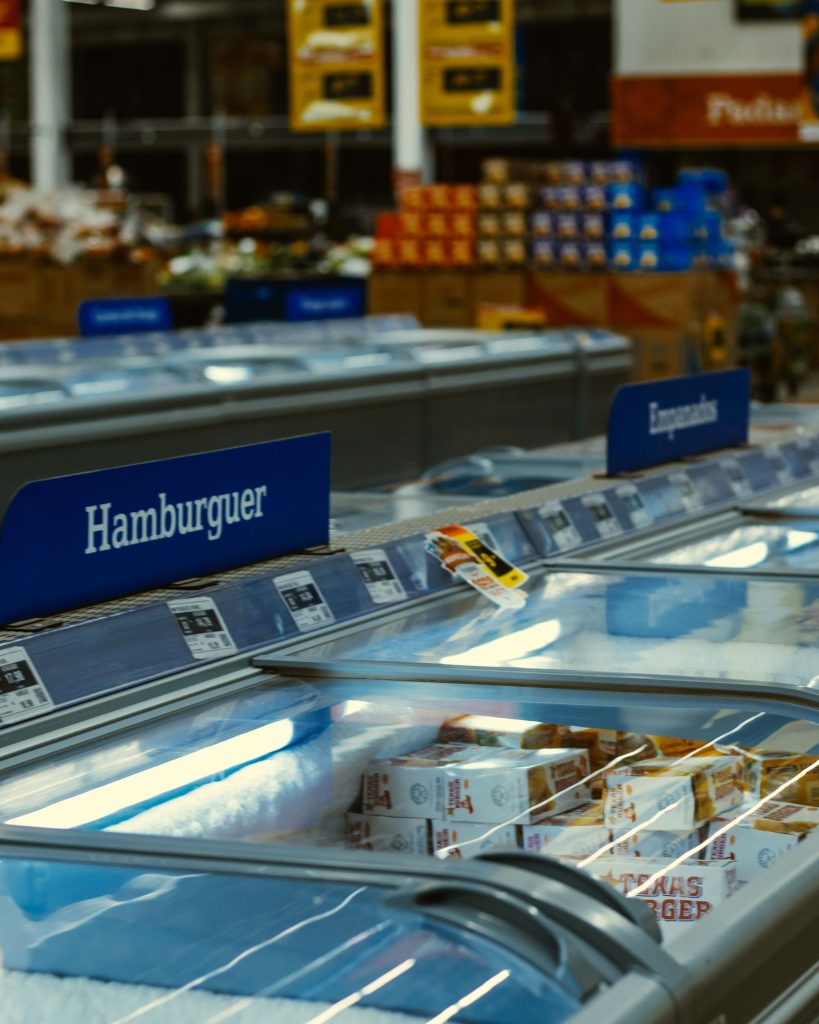 Chest freezers with frozen food in a supermarket aisle