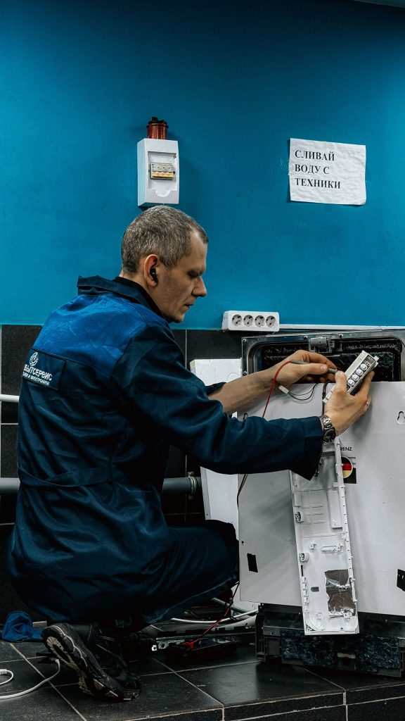 Chill Repair Pro technician in a blue uniform repairing a home appliance