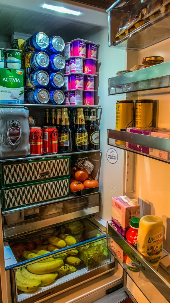Clean, well-organised refrigerator filled with drinks, fruit and dairy