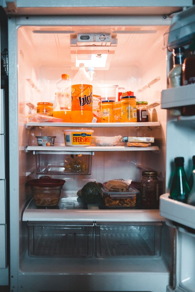 Jars and food containers stored on clean refrigerator shelves