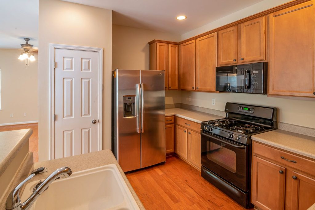 Modern kitchen with a stainless steel refrigerator and wooden cabinets