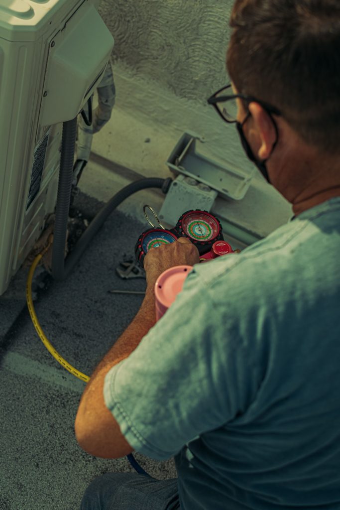 Technician checking refrigerant pressures with a gauge set