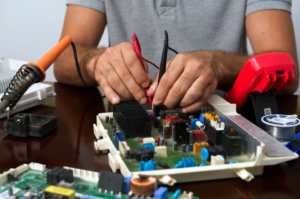 Technician repairing an electronic control circuit board