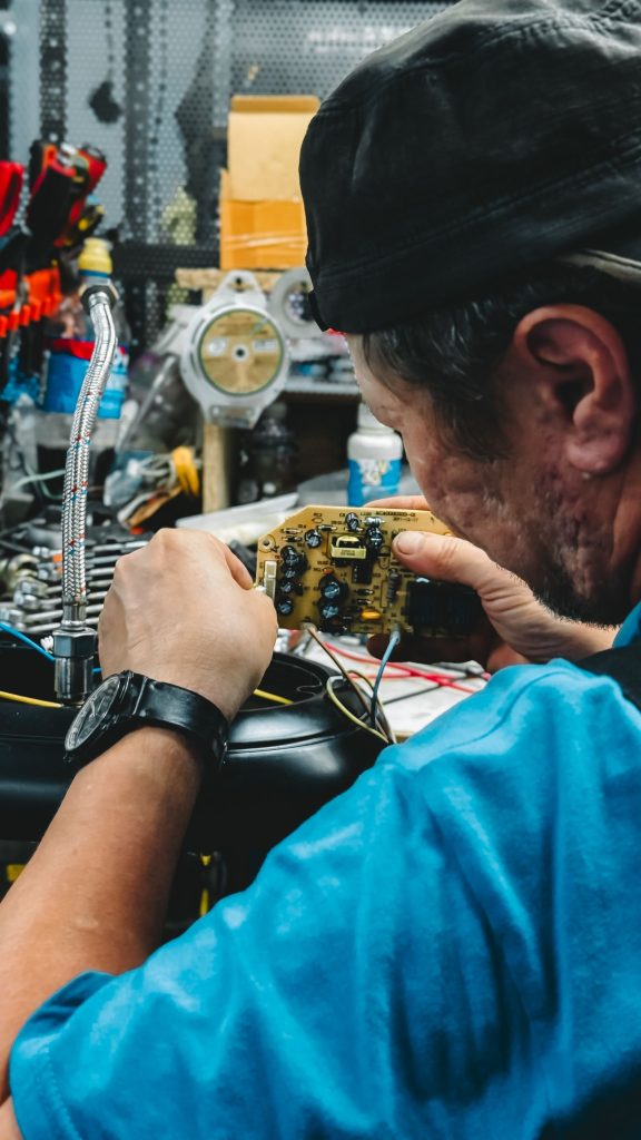 Technician repairing electronic components at a workbench
