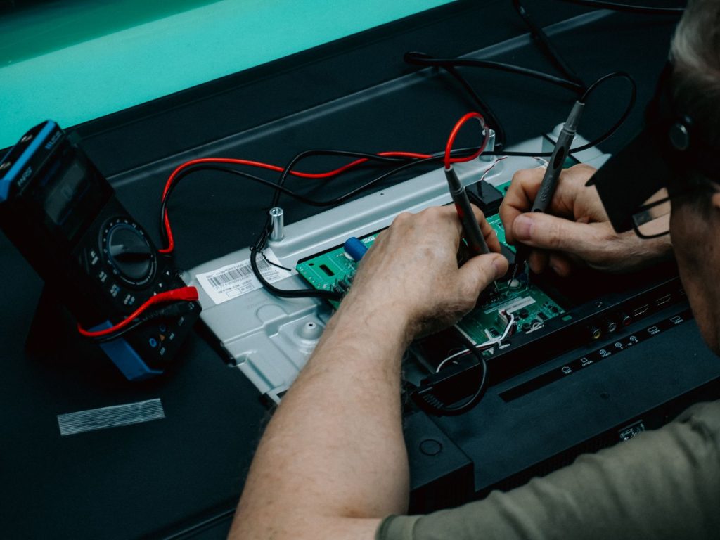Technician soldering a refrigerator control board