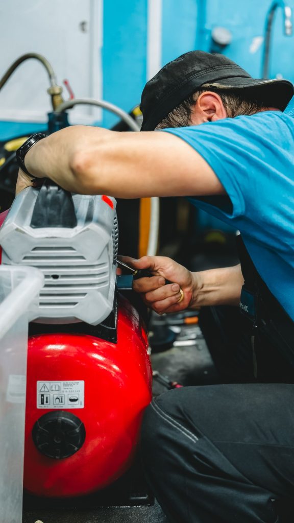 Technician working on a compressor with hand tools